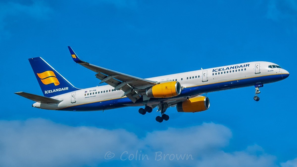 Icelandair Boeing 757-200 TF-FIN on approach with its landing gear down, in navy, white and yellow Icelandair colours, photographed in 2006 against a blue sky.