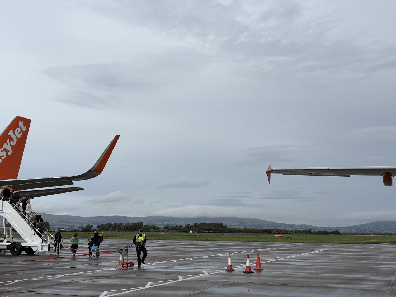 An easyJet Airbus A320 on stand, its wingtip and sharklet visible against a grey sky.